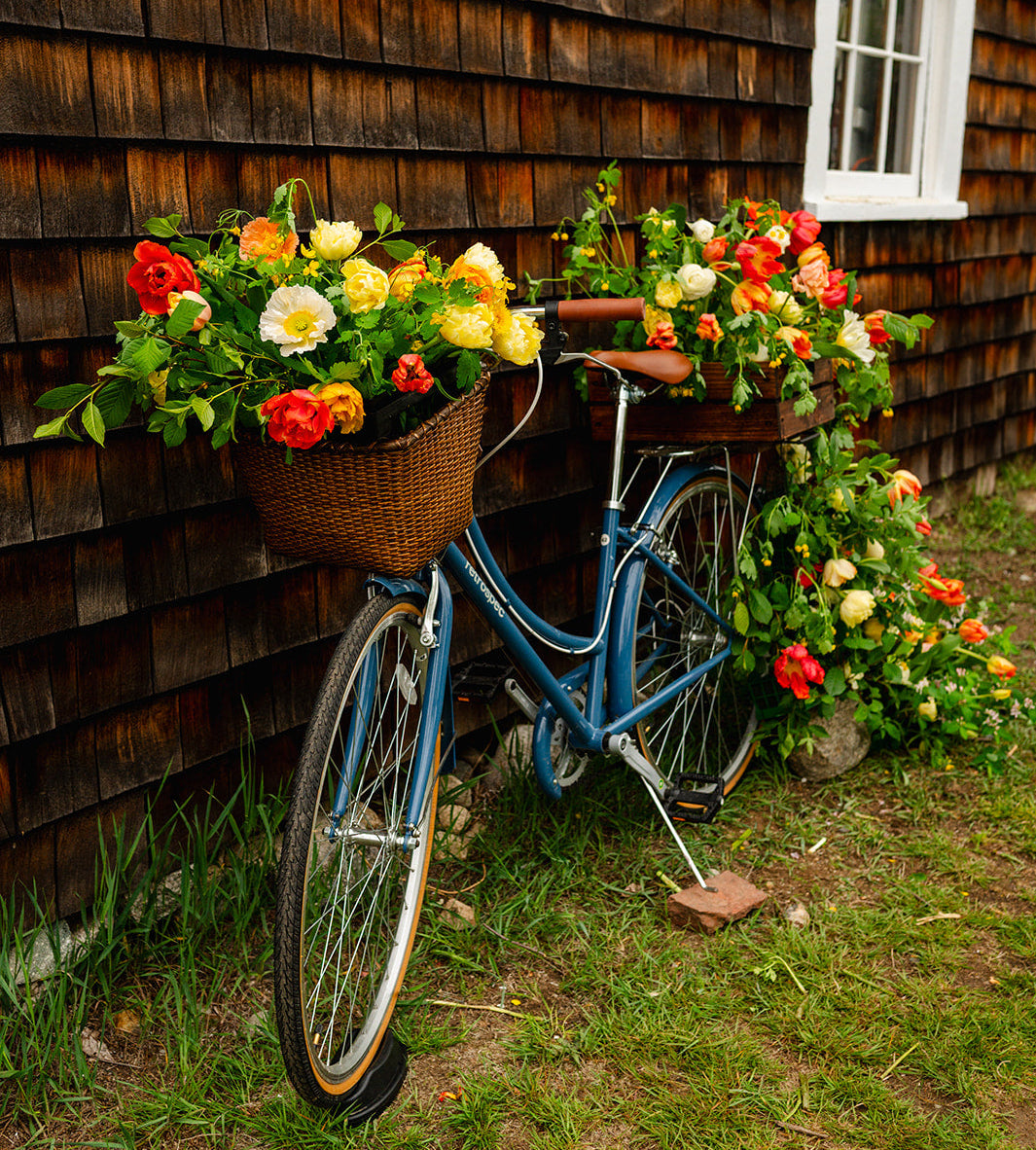 Cross Street Flower Farm's bicycle with flower baskets against the barn shop