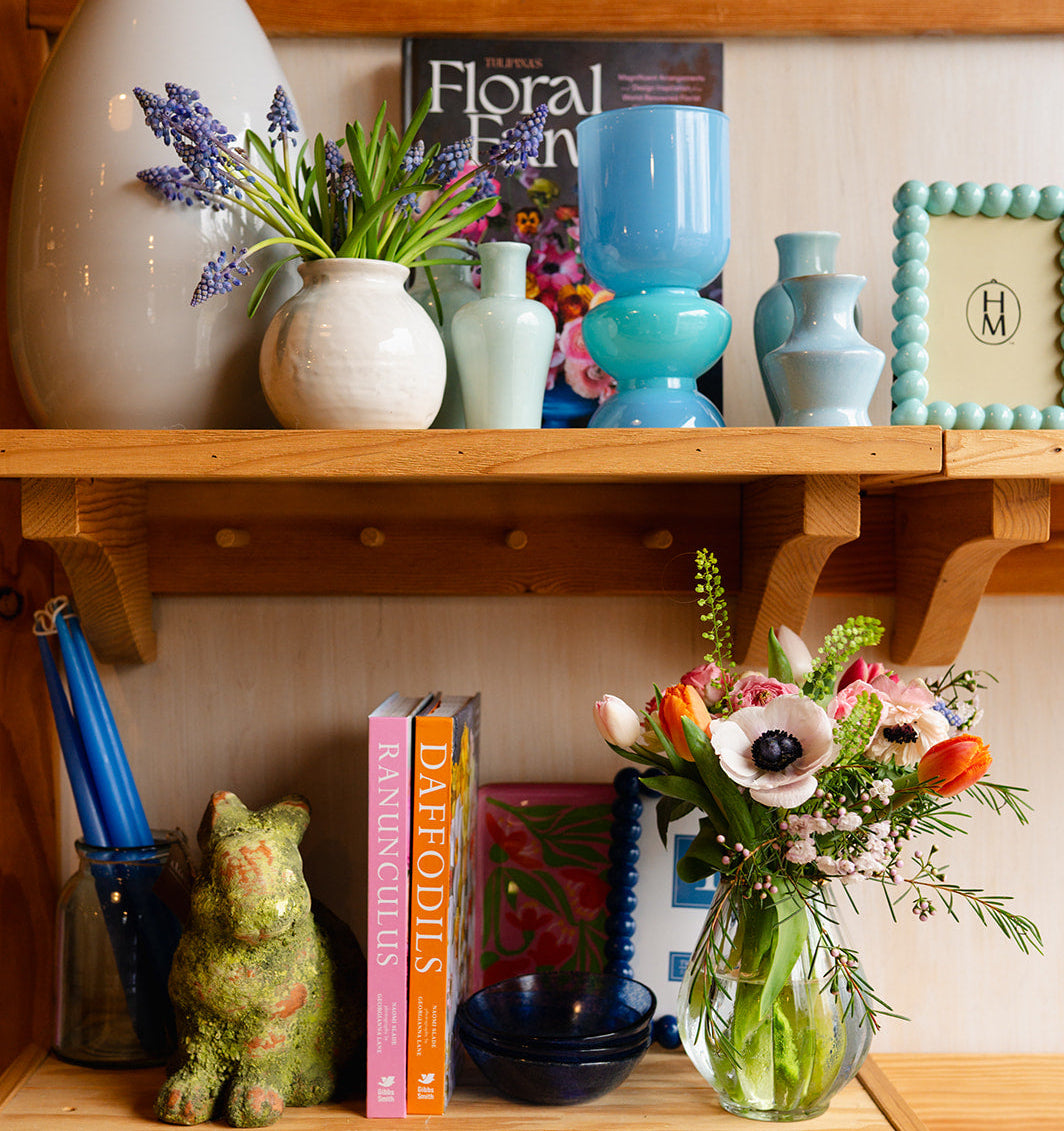 Wooden shelf with decorative items including vases, books, and a small figurine.