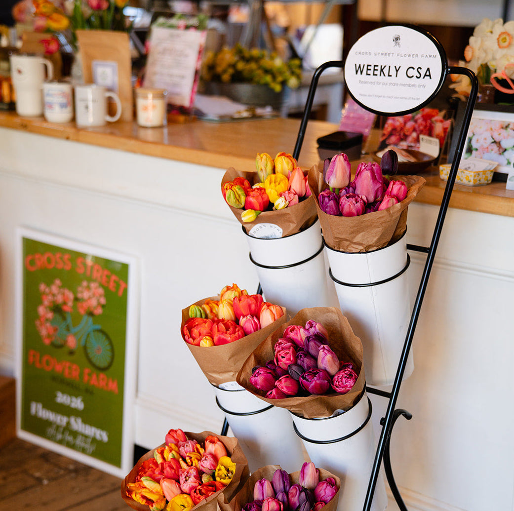 Flower stand with tulip bouquets in a cafe setting